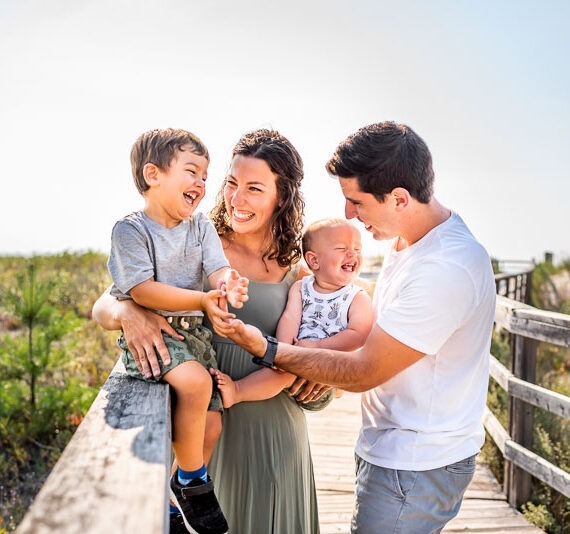 Parents with their children on a bridge.