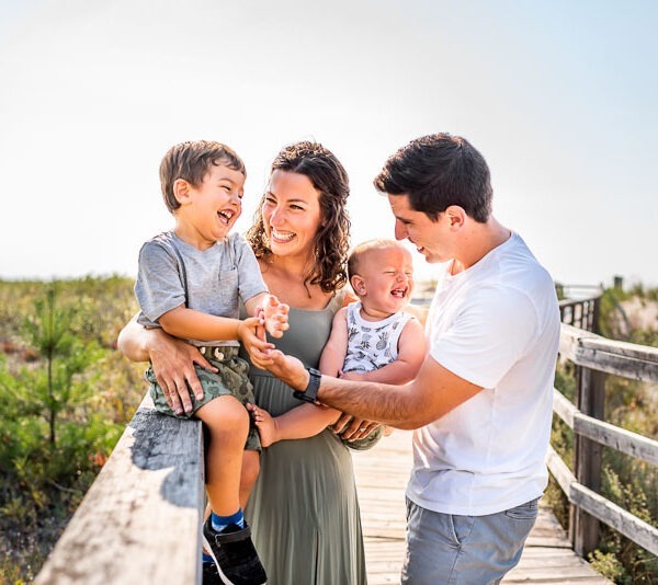 Parents with their children on a bridge.