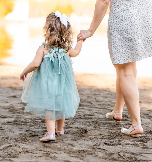 Mother and daughter walking on the beach.