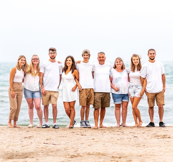 Large family standing together on a beach.