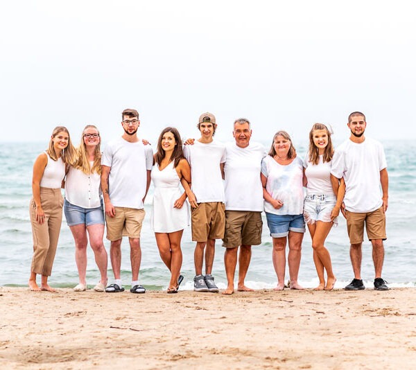 Large family standing together on a beach.