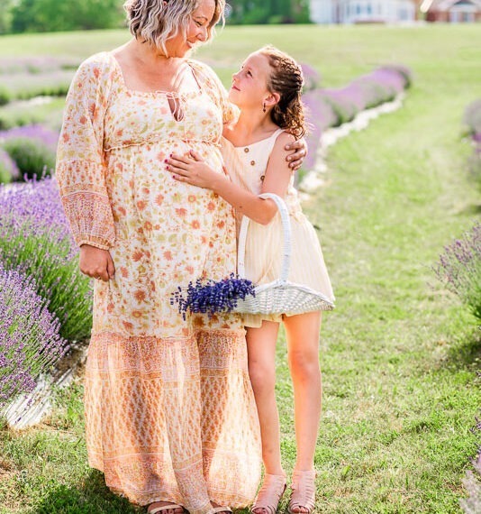 Pregnant mom with her daughter in a lavender field.