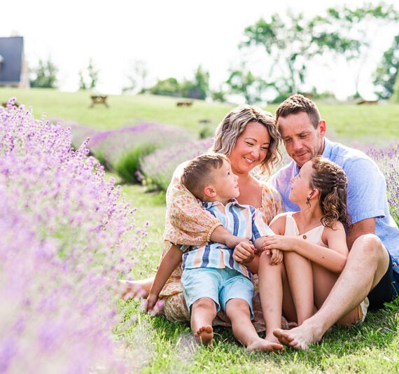 Family sitting together smiling in a lavender field.