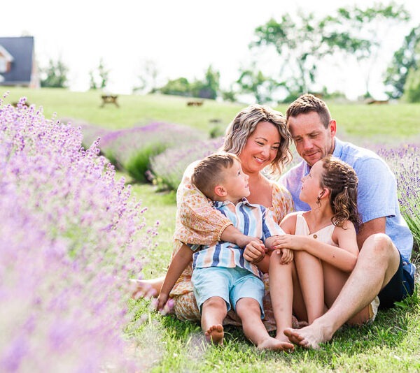 Family sitting together smiling in a lavender field.